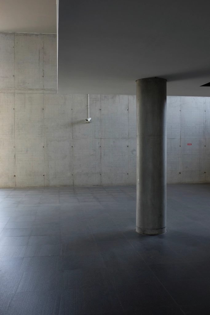 Exposed concrete podium slab above an empty parking garage